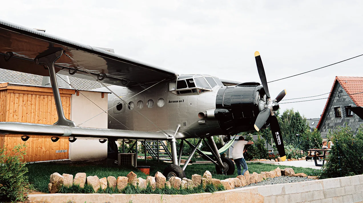The Antonov An-2 in the garden with a terrace beneath the wings